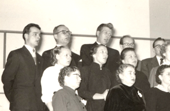 Otanmäen sekakuoro esiintyy joulujuhlassa 1954, johtajana opettaja O Leskinen. valokuvaaja Hynninen
(kuva Kainuun museo)

